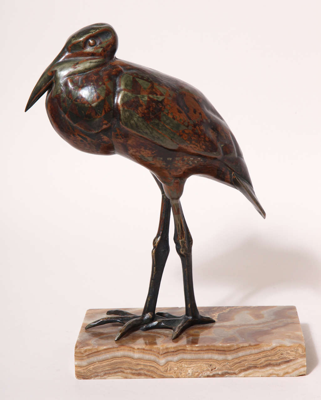 The dinanderie body of the stork is made of copper with inlaid silver and the legs are solid bronze mounted on a brown marble base.

Signed:  'Bigard' on underside of tail and on marble base
