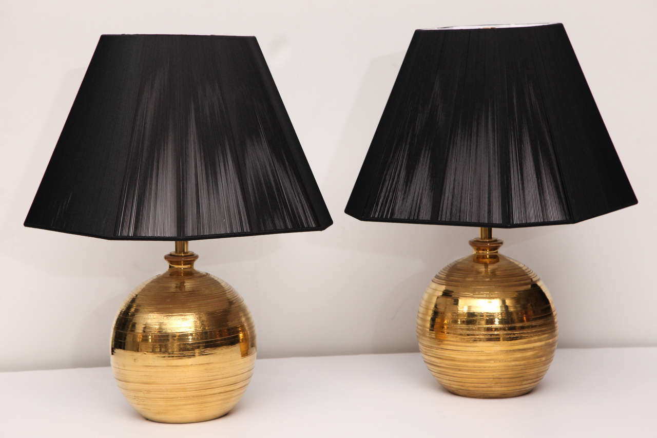 A pair of gilt glazed ceramic table lamp by Bitossi for Bergboms, Sweden.

Shades pictured are 14