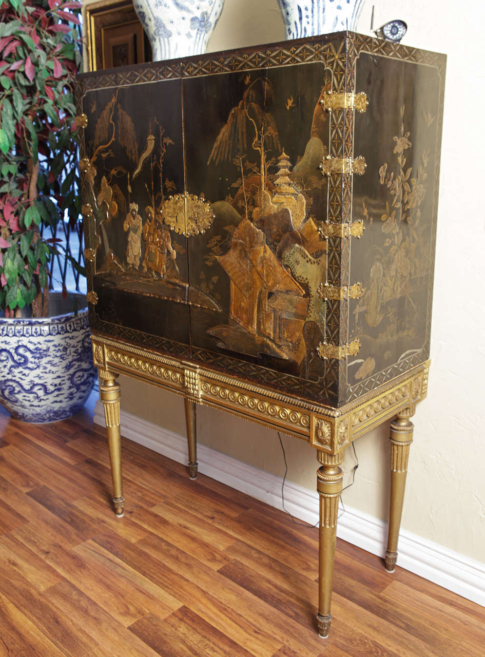 Beautiful early 19th c Black lacquered English cabinet on stand , The cabinet has beautiful raised detail with a gilt original stand and inside drawers. Original hardware