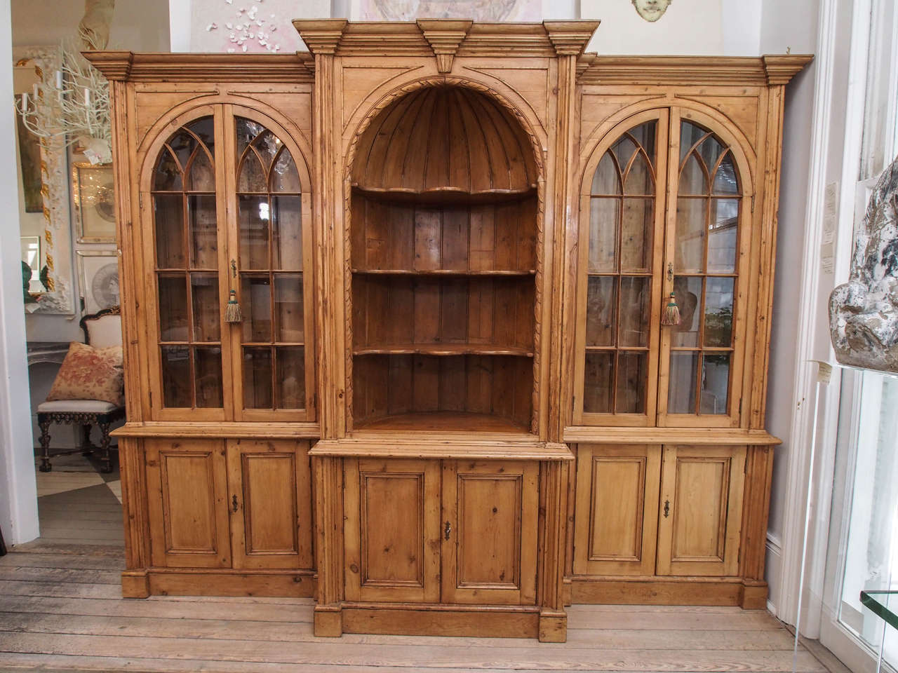 Exquisite solid English Pine Breakfront Bookcase is a perfect piece to fill a tall and wide space with limited depth. Hand carved crown and base mouldings, and beautifully detailed arched center and flanking side cases. The center case is 35"