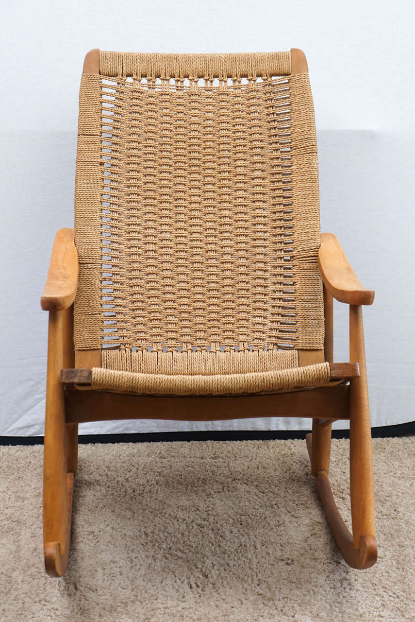 Comfortable rope rocker reminiscent of a design by Hans Wegner. The wood shows appropriate wear while the rope is strong and intact. Comfortable, practical and simply stylish.