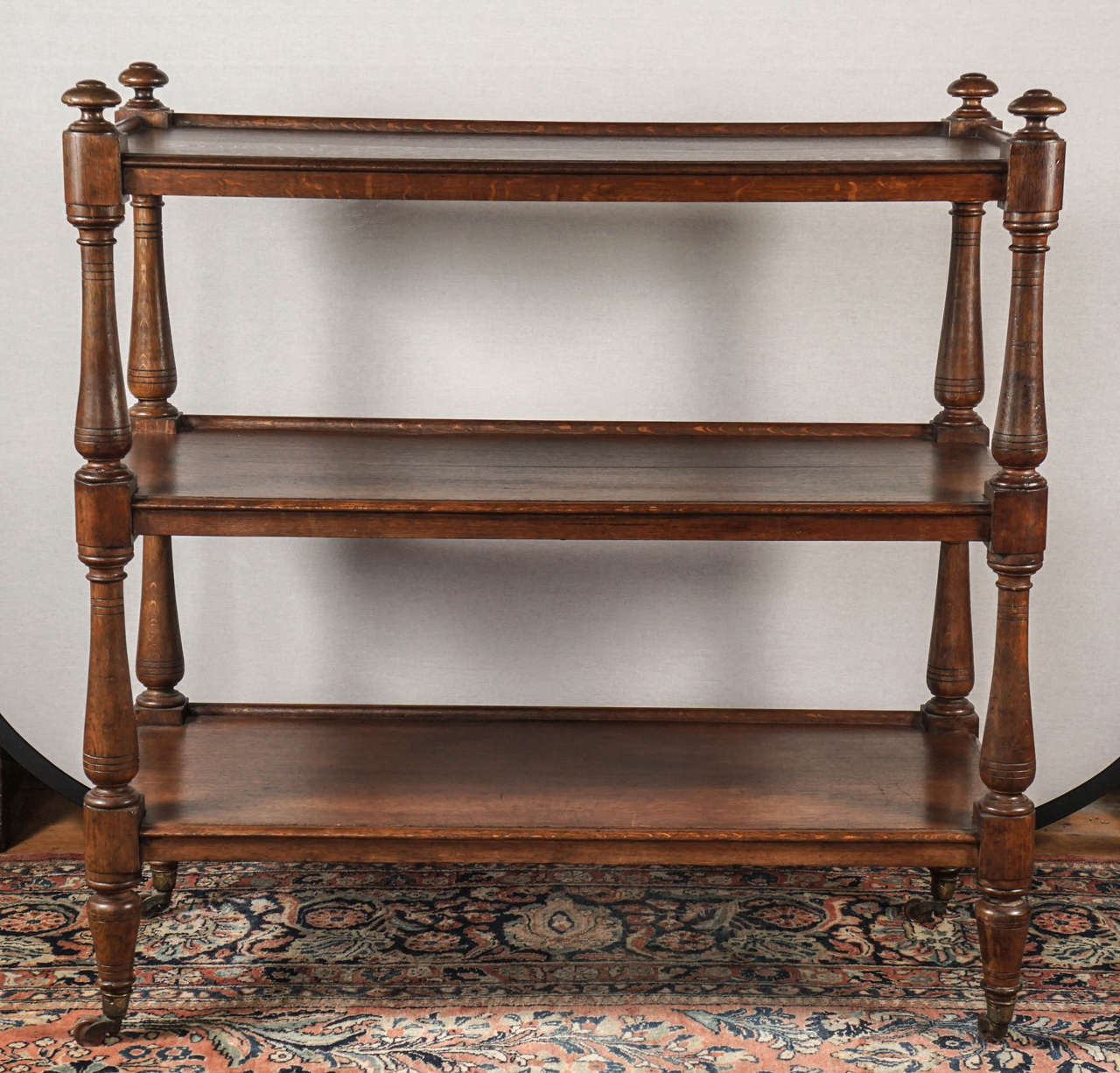 Nice English 19th century oak etagere/trolley. Three shelves united by turned supports on casters.