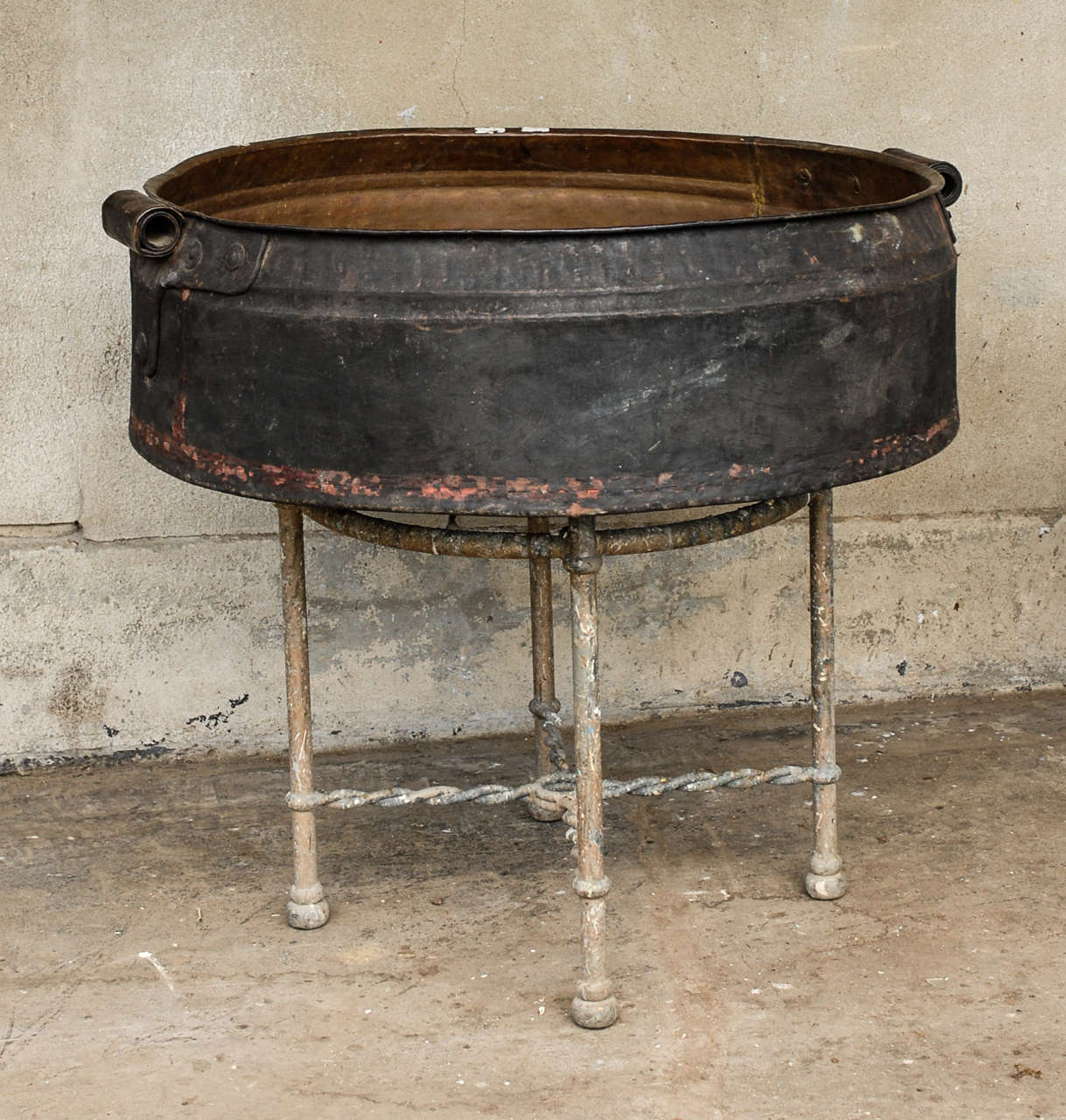 A very large South Indian hand-hammered copper vessel with rolled and riveted handles from the 19th century. The stand shown in the picture is not included.