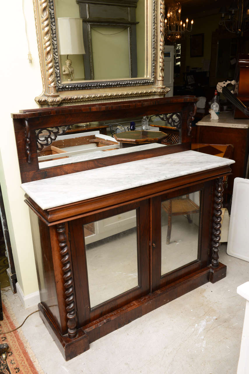 This is a very nice rosewood server. They used to serve drinks off the top as the marble would keep the drinks cool, its all original to either side of the base there are two candy twist pillars, and inside the base has the original shelf. The