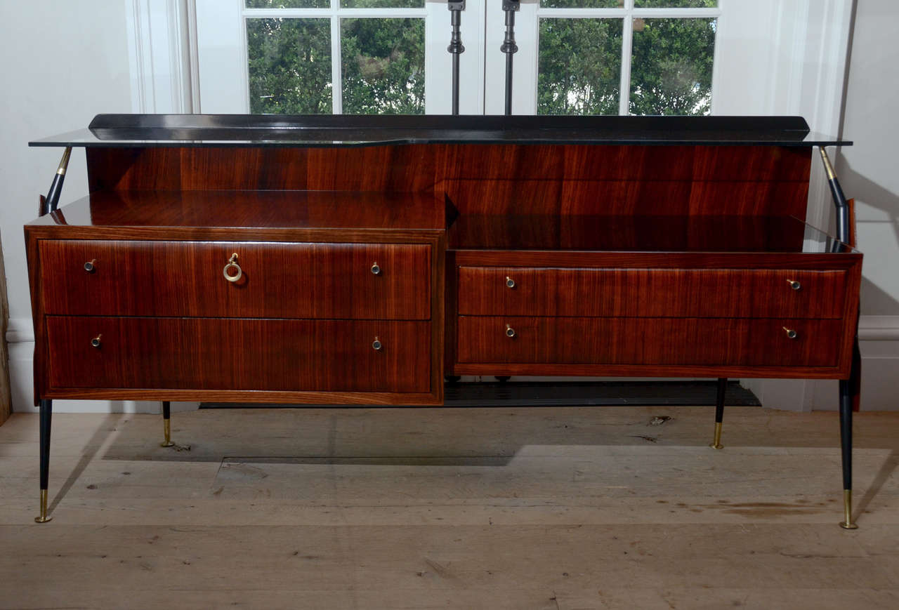 Stunning and elegant midcentury Silvio Cavatorta rosewood credenza with smoked glass top. Four drawers with brass knobes allow for great storage. Brass finish on the legs.