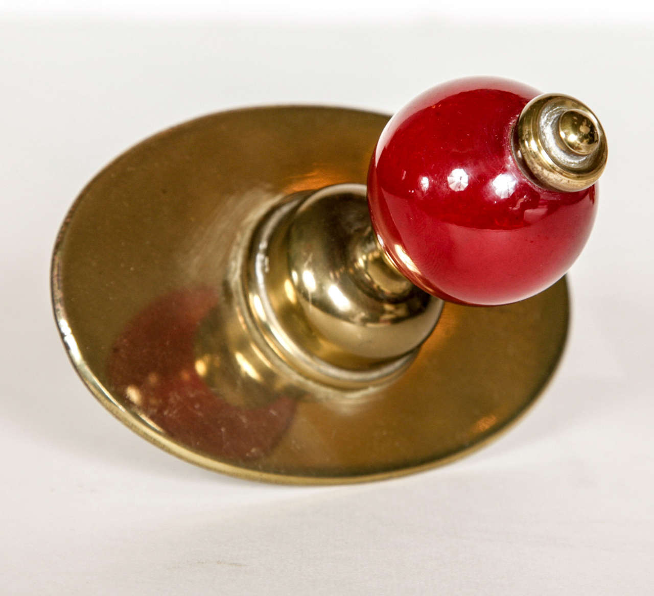 Four Brass Coat Hooks, each with deep red glass bauble. Born in Milan in 1913, Dominioni was one of the pioneering product designers of the 1950s – his range of cutlery can be seen at the Museum of Modern Art in New York