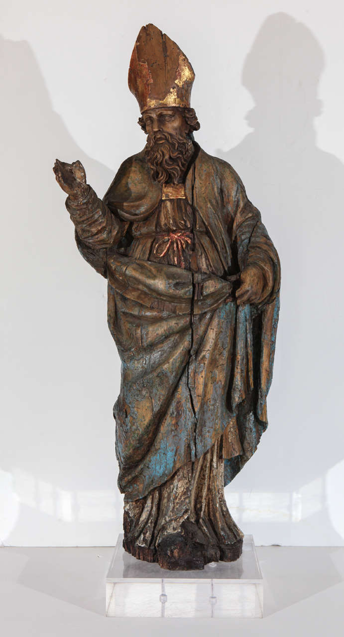 Parcel gilt, statue of a bishop in flowing robes with paint traces mounted on a Lucite pedestal.