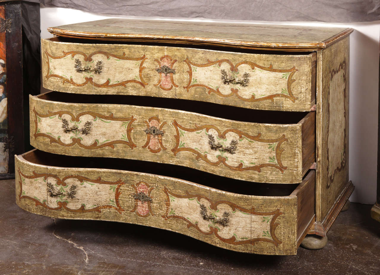 Elegant antique hand painted chest of drawers from Italy, circa 1860, featuring three shaped drawers across the front with original painted designs and finished with four bun feet at the bottom. Both sides and top also feature some detailed painted