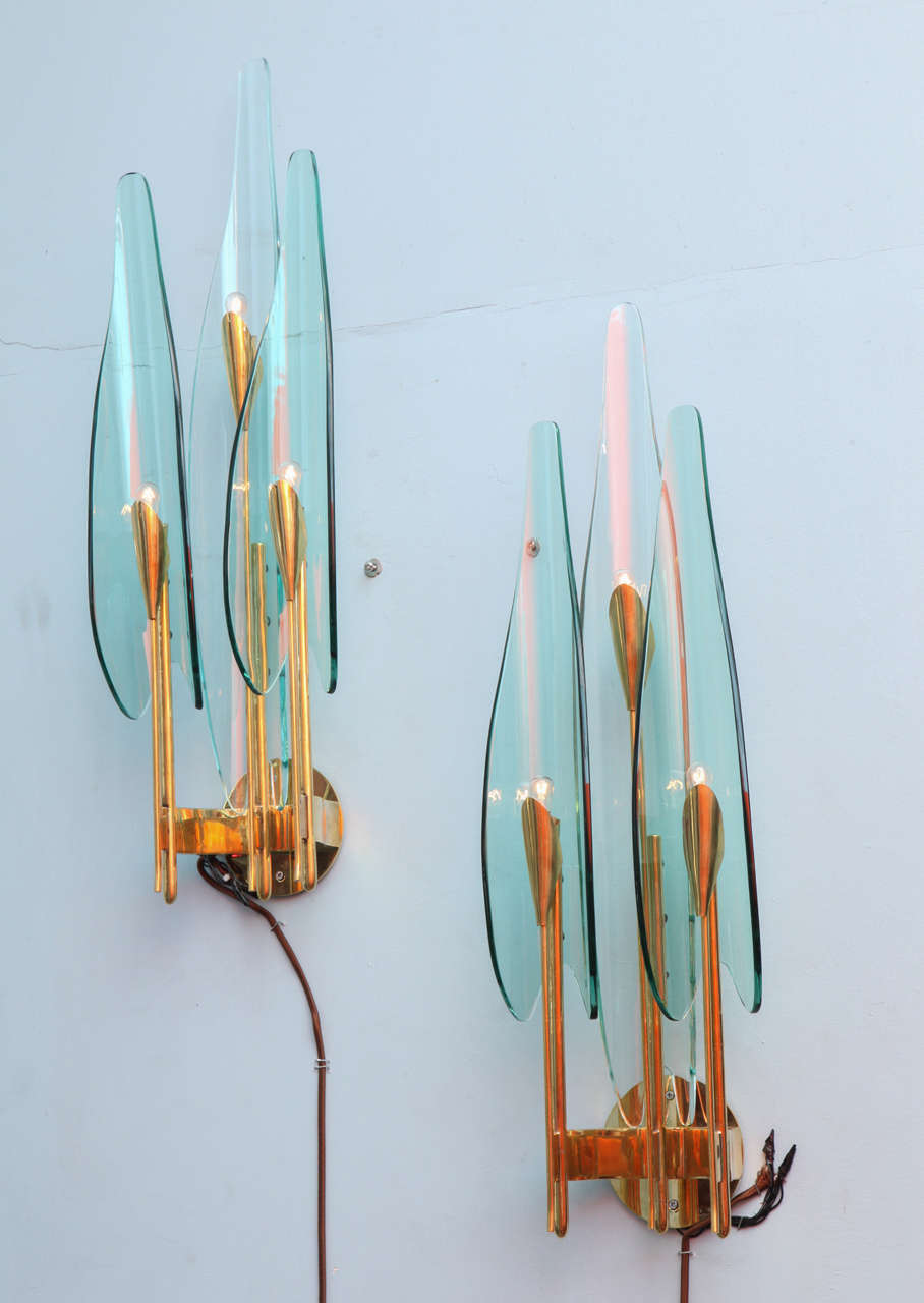 Pair of three light sconces with elongated elements resembling floral petals, in pale aquamarine and clear crystal. Polished brass structures & newly made back plates for mounting. Pieces from the Dahlia series are hard to find and very sought