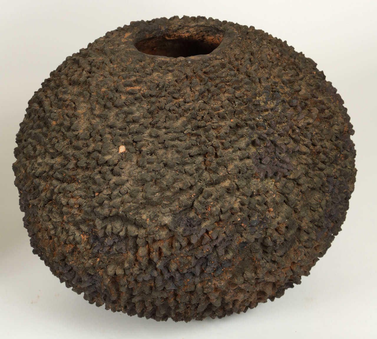 Lidded volcanic clay Lobi pot densely and organically covered with points.  

The Lobi are an ethnic group that originated in what is today Ghana. Starting around 1770 many of the Lobi migrated into southern Burkina Faso. Currently the group