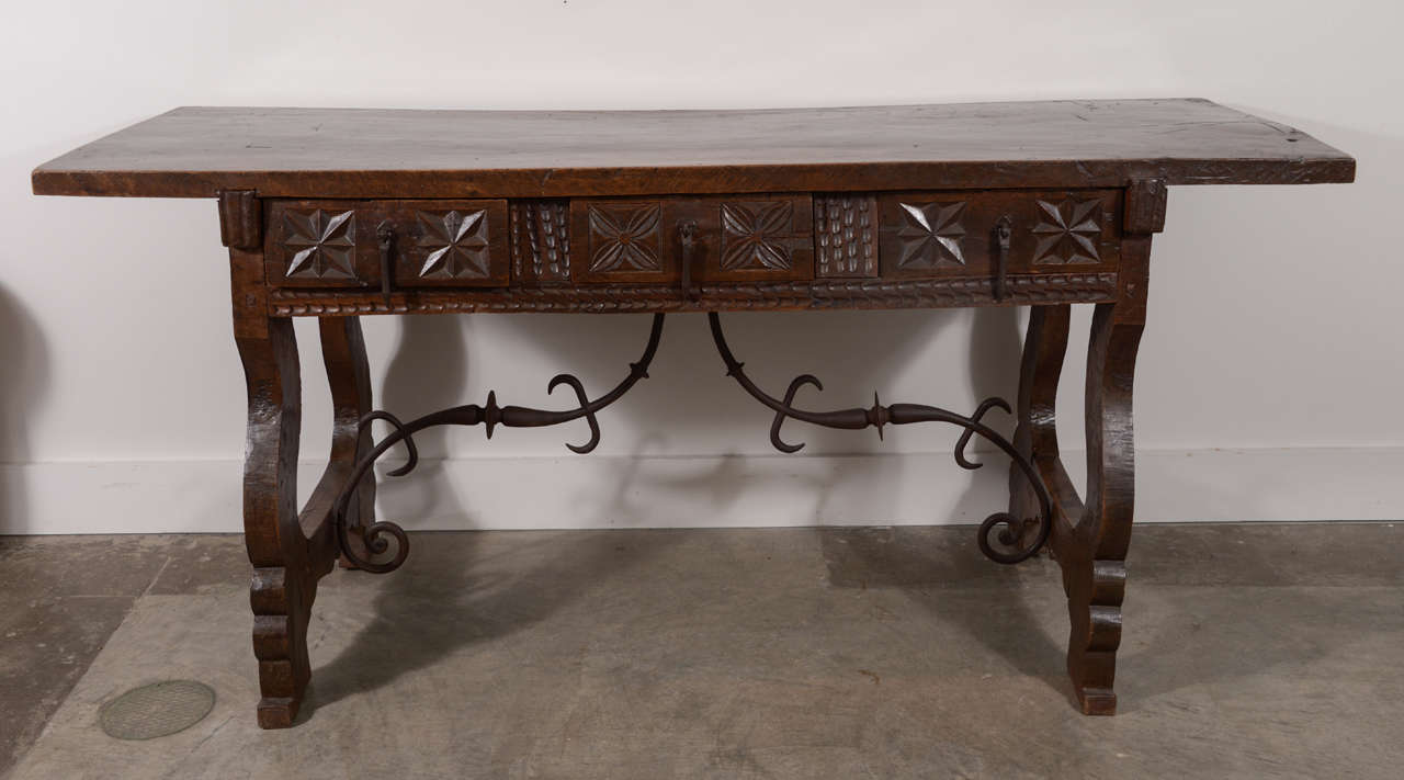 17th c. Single Plank Top Spanish Walnut Table with Iron stretcher and Lyre shaped legs.  Three drawers with different carving on each drawer.  Original hardware.