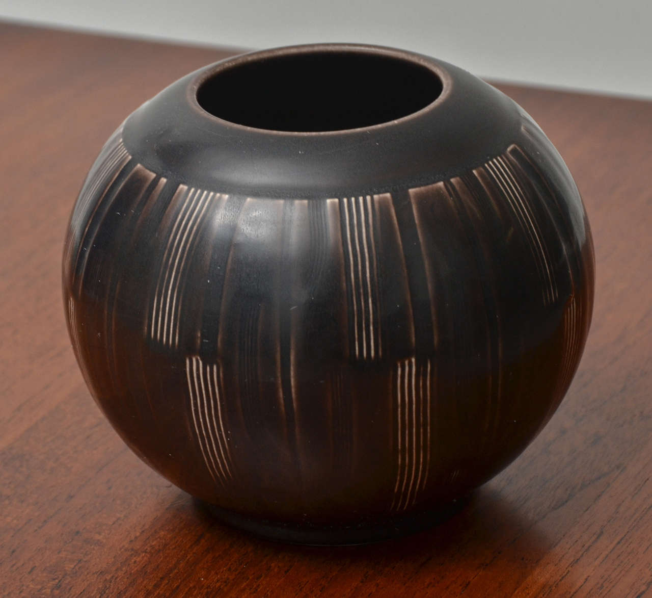 Stylish dark brown orb with Deco-like sgrafitto lines forming vertical segments
on the body of the vase.  Nils Thorsson for Aluminia, Danish, 1951.  Shape & Style began in the 1930's and remained popular in Solbjerg  pottery.