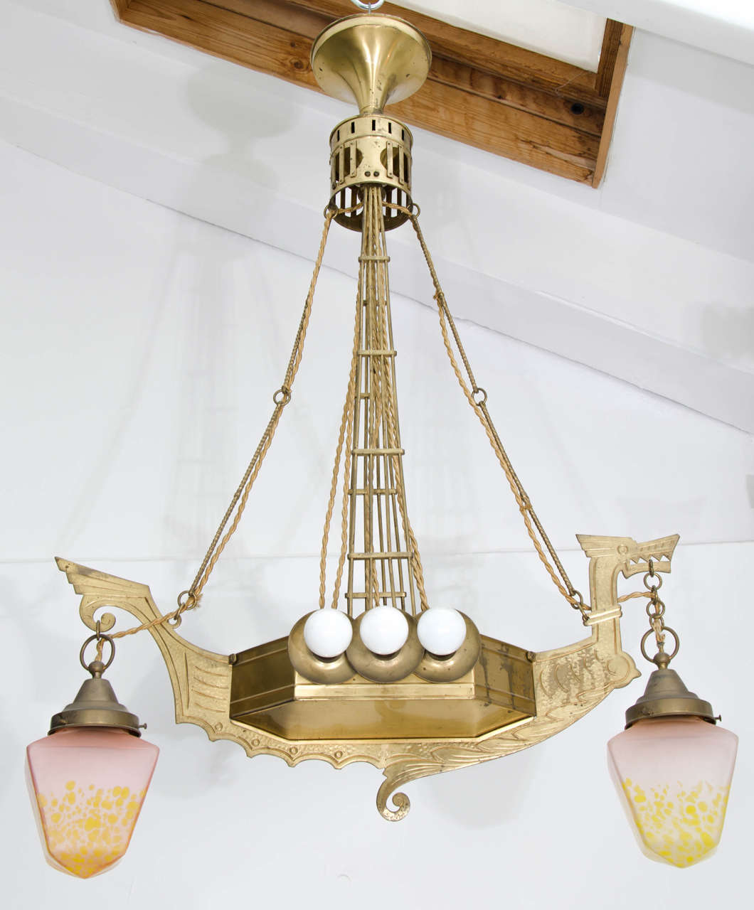 Highly unusual Art Nouveau or Secessionist chandelier. Early 20th Century, European, probably German or Austrian.

The chandelier has a brass frame - partly hammered - in the shape of a viking ship with dragon's head at the prow. The frame carries