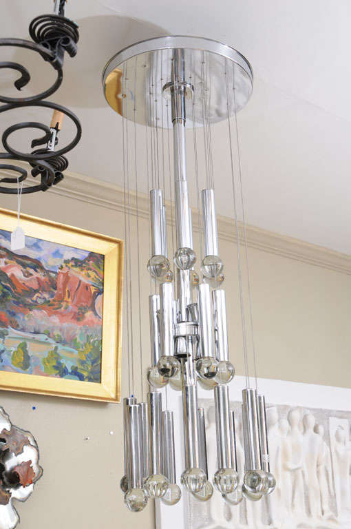 Cascade Chandelier by Gaetano Sciolari
with chrome centre stem, 14" round ceiling mount
and 24 chrome finished Brass tubes with solid glass balls
suspended in three-tiers on thin chrome chains.
Seven sockets for 25W candelabra bulbs.