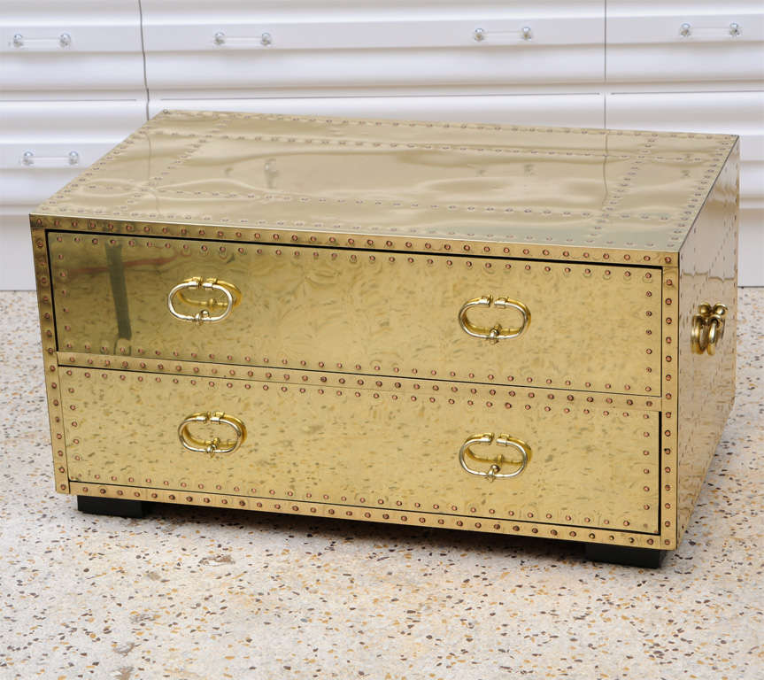 A versatile and handsome 2-drawer chest by Sarreid, Ltd. Brass-clad on all sides, it serves equally well as a large nightstand or a coffee table. Solid copper nails add a decorative touch.