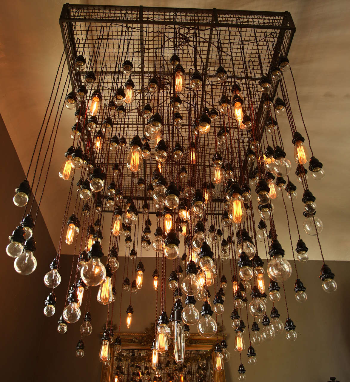 John Varvatos commissioned Alexandre Ferucci to design this fixture, which ended up being one of the signatures of their luxury retail showrooms across the world. 

A mixture of functional and non-functional industrial bulbs. Fixture is able to be