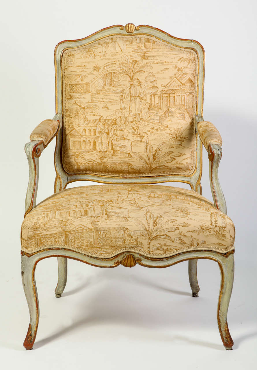 A pair of Italian, 18th century parcel-gilt and pale-grey painted armchairs with a shaped back decorated with shell-carved crest, scrolling armrests on a serpentine seat on cabriole legs,
Covered with cream Chinoise upholstery.