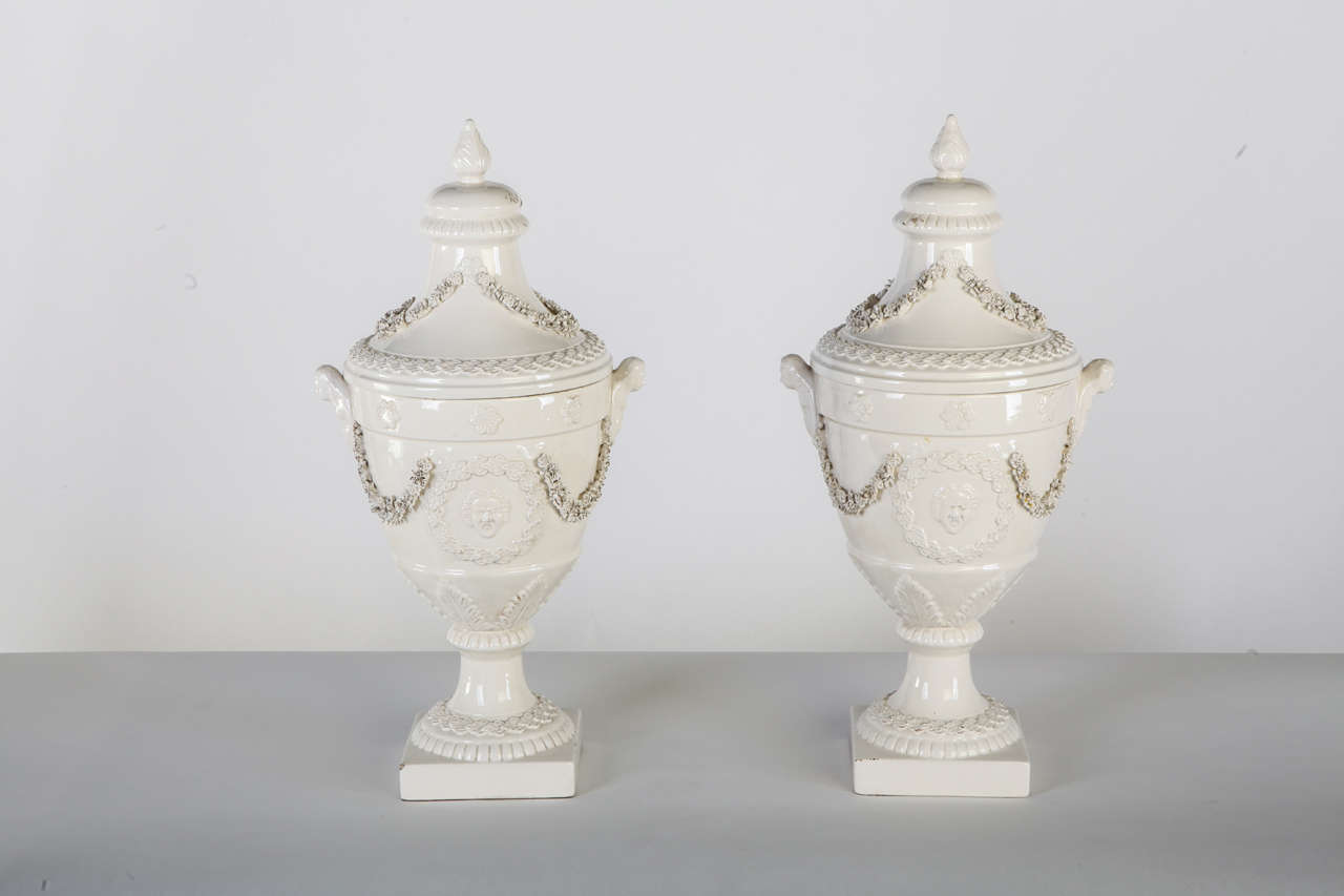 A pair of Italian white ceramic urn vases, manufactory of bassano del  grappa. Early 20th century.<br />
44 X 21 cm.