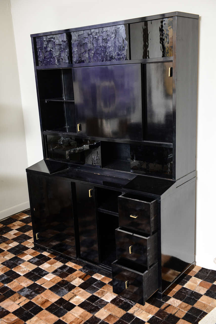 The rectangular top with sliding black glass doors over two wood sliding doors again over black glass sliding doors above a base cabinet with doors and drawers. Sold Sothebys New York, December 2001, lot 201.