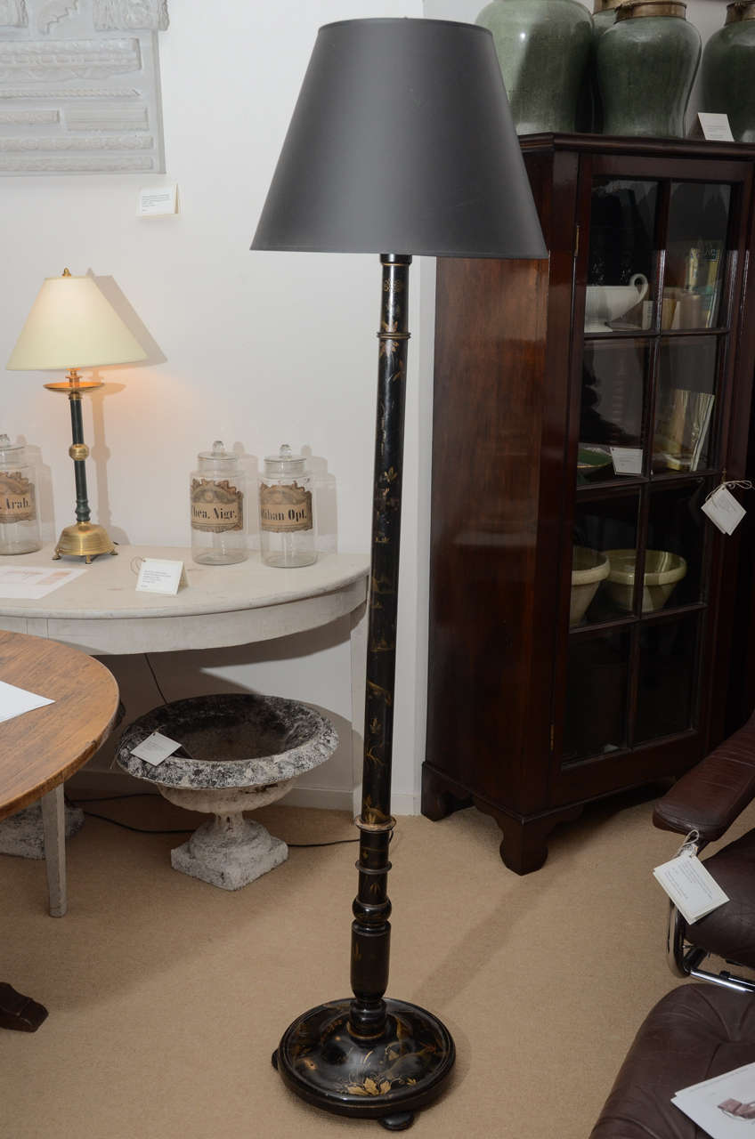 An ebony lacquered floor lamp with attractive gold botanical decoration. Wired for USA.