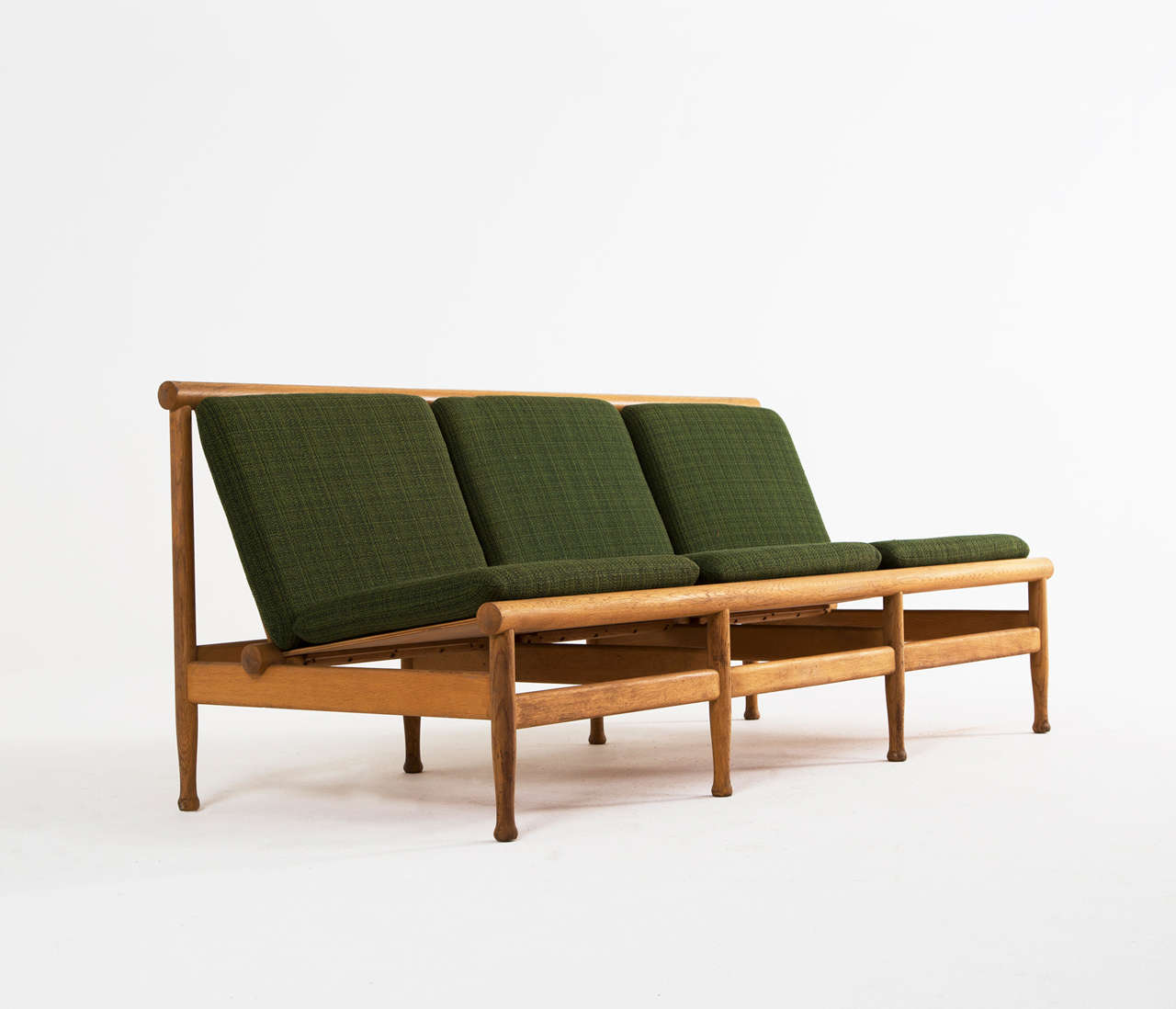Very well made Danish solid oak three seater sofa, probably by Børge Mogensen, produced at Søborg Møbelfabrik. The sofa consists of a rounded oaken frame with slats forming the seating and the backrest. The cushions are covered with a classic green