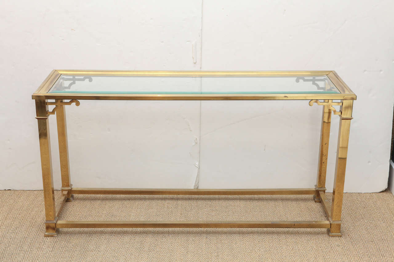 1960's Mastercraft console table in brass with inset glass top featuring Chinoiserie accents.