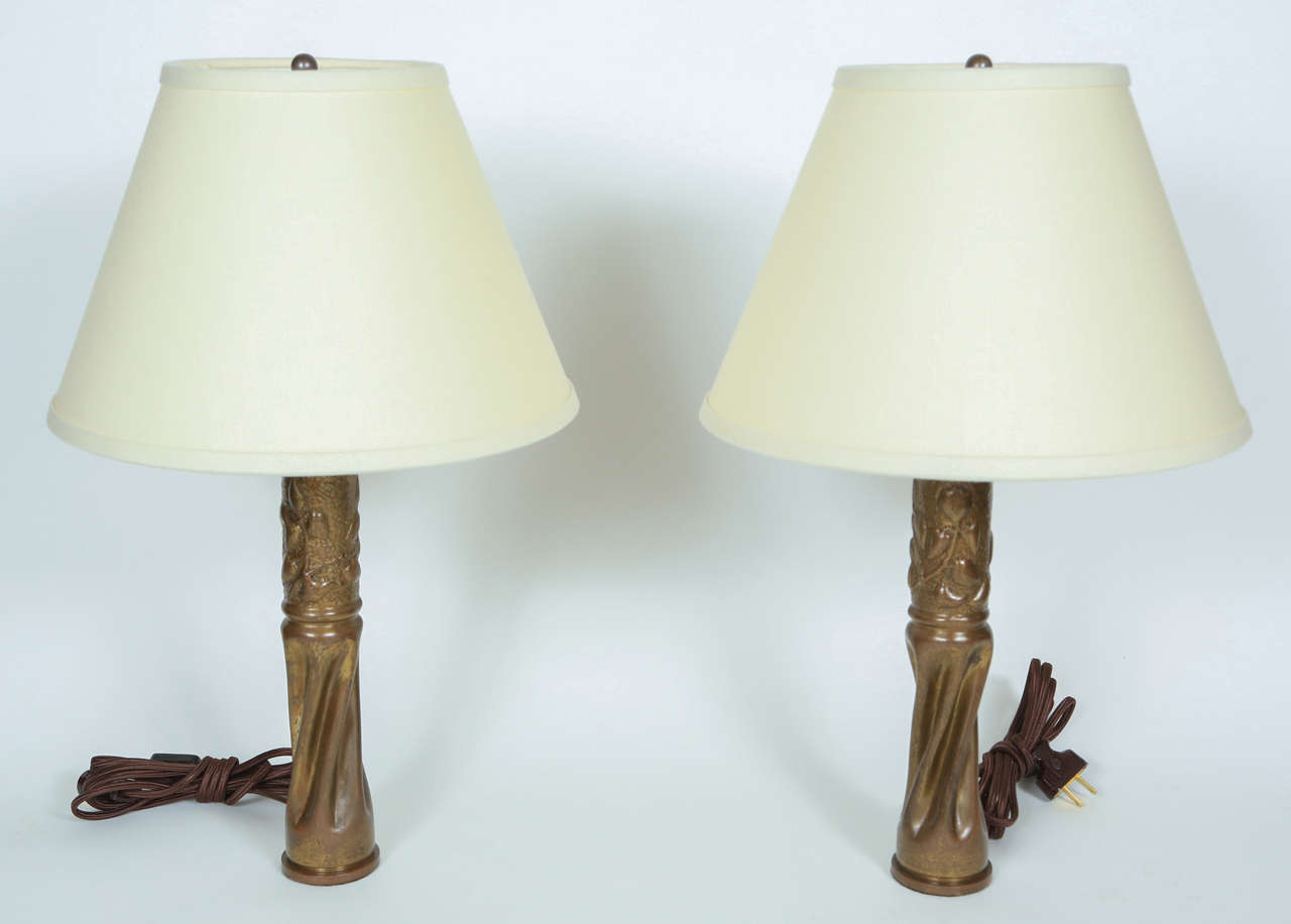 Pair of vintage trench art brass bullet casings made into lamps. Newly rewired and new ivory linen shaeds.