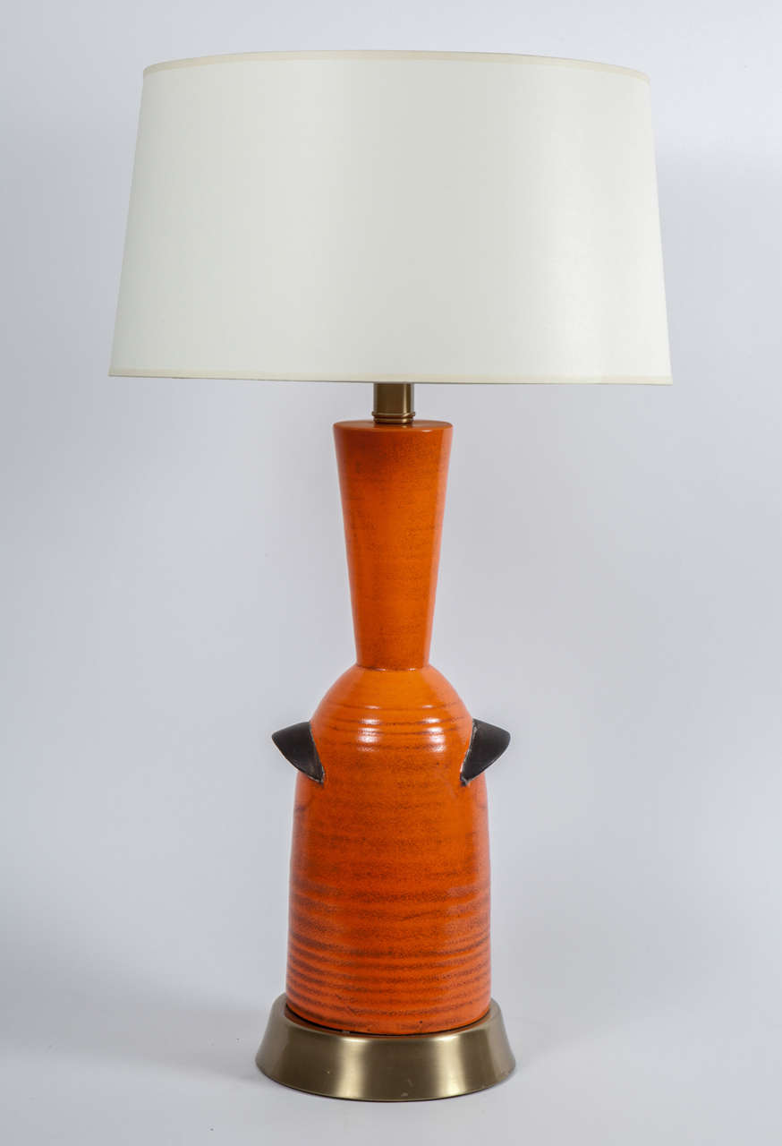 Lampe de table en poterie de céramique texturée orange avec quincaillerie en laiton par Raymor.  Signé.  Italie, vers 1960.

Dimensions :
38 pouces de hauteur à l'épine dorsale
27.hauteur de 25 pouces à la douille
8 pouces de large à la base
