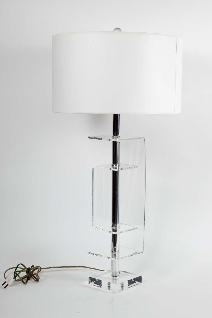 Lucite table lamp with chrome accents.  USA, circa 1970.  Lucite inverted U-shaped forms on a square base with a polished chrome stem.  

Dimensions: 25 inches H (shown with 8 inch harp)
