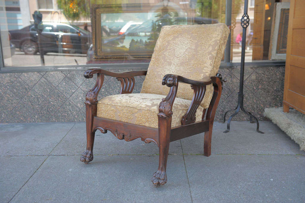 This is the earliest known recliner.  Originally invented by the Englishman William Morris, these chairs are highly sought after and extremely well made and comfortable.  This one is especially finely carved in solid mahogany.  Handsome claw feet