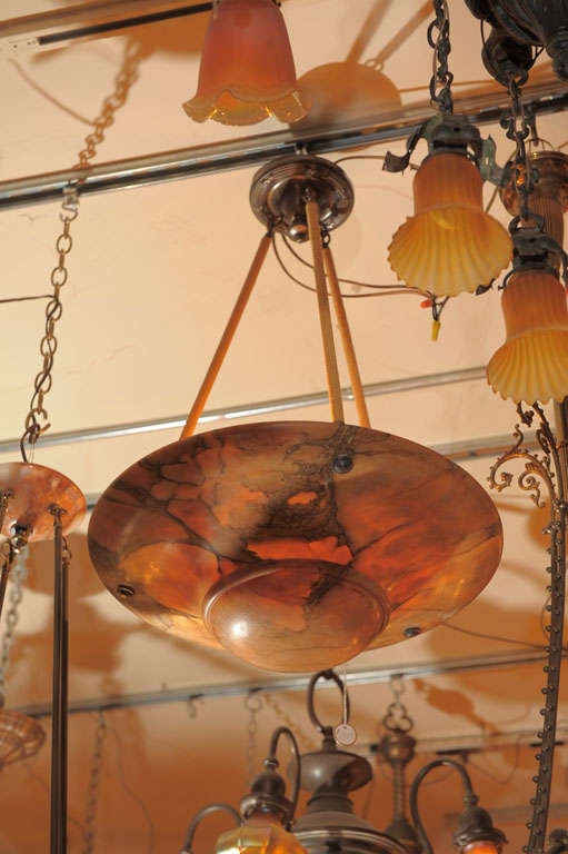 This alabaster chandelier has exotic amber and black coloration and gives very warm light.  It is suspended by three ropes leading to the canopy.  A fine example of good alabaster.