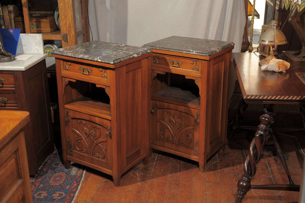 Pair of hard to find wood and marble nightstands.  Will make any bedroom complete.  Nicely carved, well made and indeed a pair, as they are mirror images of each other.  Nice original brass handles