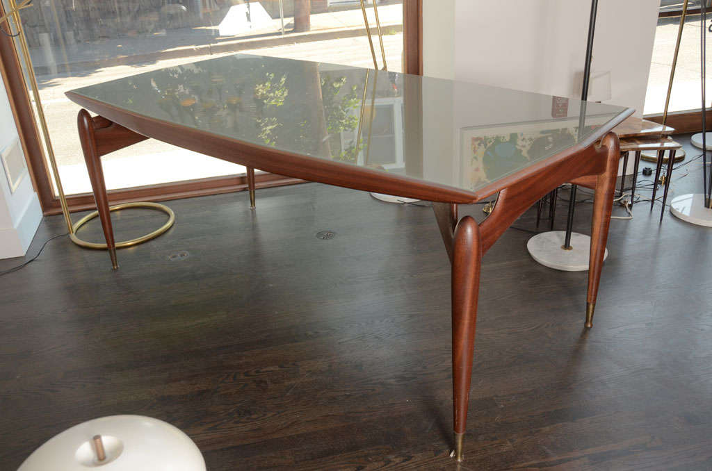 Italian Mahogany Dining Table in the style of Gio Ponti.  Gorgeous mahogony base with sculpted legs and apron.  The top surface has an inlaid sand blasted glass top cut to the slightly boat shaped top.  All original including glass top.