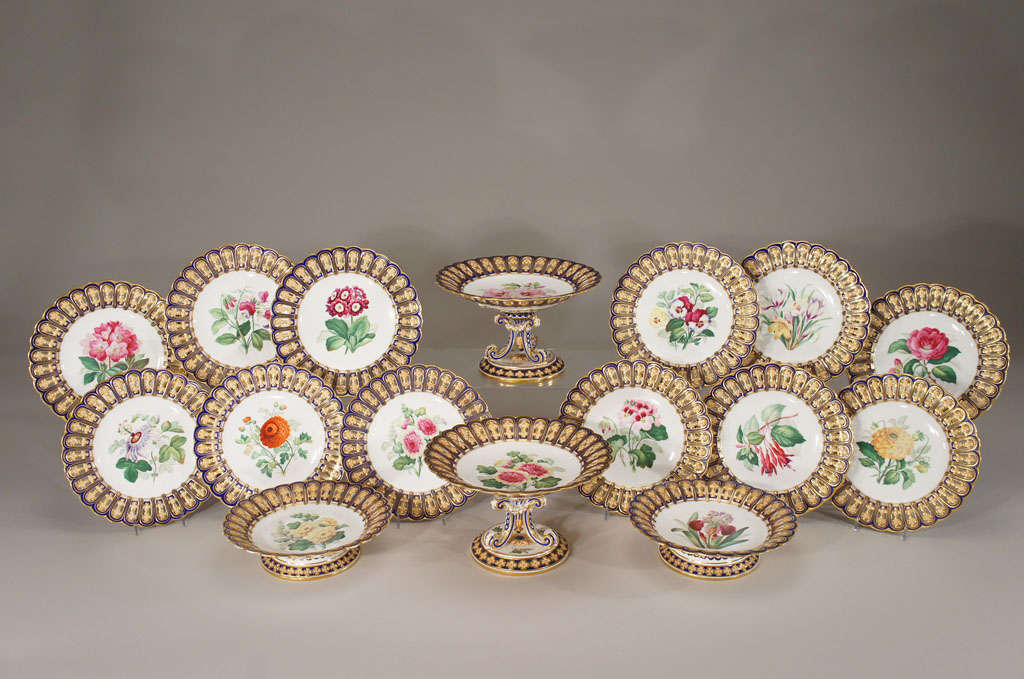 A complete hand painted dessert service made by Minton showcases their superb talent and artistry. Gorgeous specimens are featured in the centers of each plate, consisting of 12 dessert plates, 2 tall compotes and 2 low compotes. The borders are