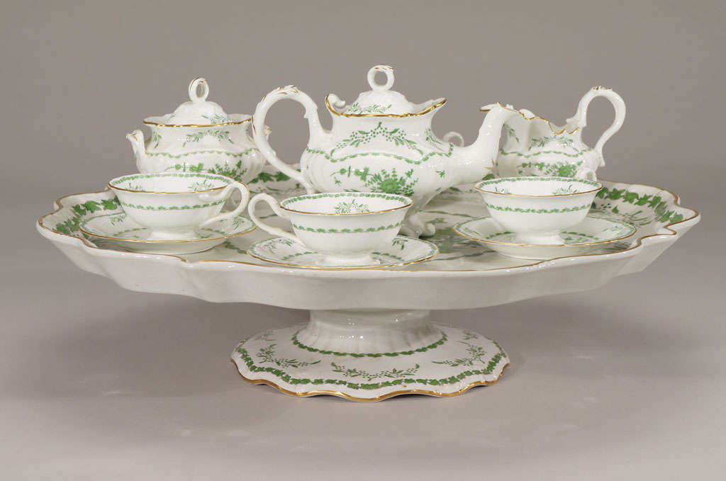 This lovely tea set for four sits on a large lazy-Susan which spins the set around for easy access. Made at the turn-of the-century it evokes the genteel shape and practicality of a full sized tea pot, four matching cups and saucers, creamer and