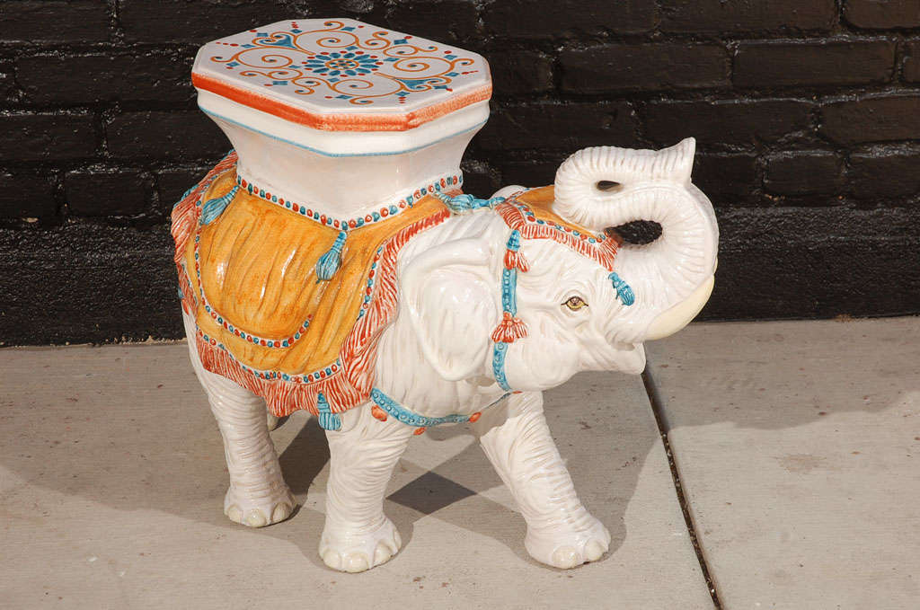 Glazed ceramic elephant garden table or stool featuring hand painted detailing in turquoise, orange, and red.