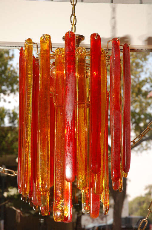 2-tiered chandelier featuring hand blown Murano glass in varying sizes and hues of red, orange and amber.