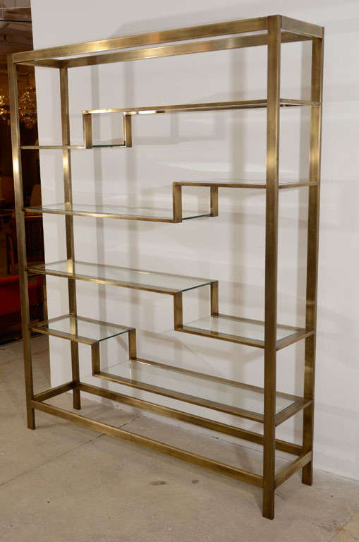 A brushed brass and glass shelf etagere by Baker Furniture Company with a wonderful patina.