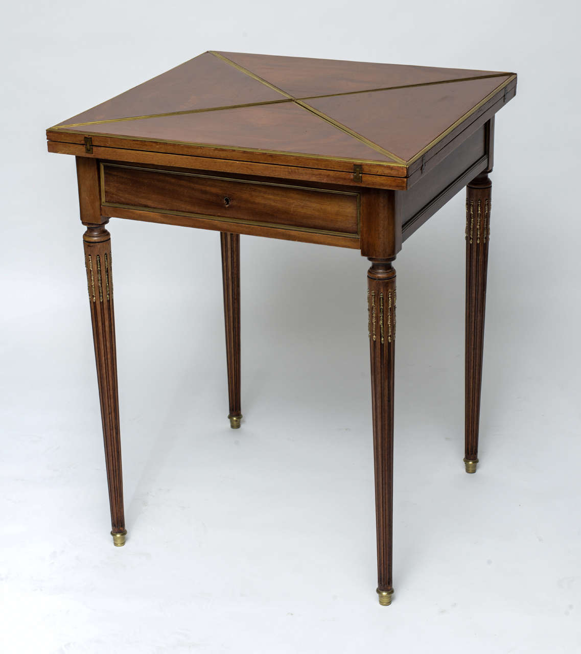 Elegant Louis XVI style card table with doré bronze trim and mounts. Top opens and swivels to reveal green felt playing area. Single drawer to store your accoutrements.