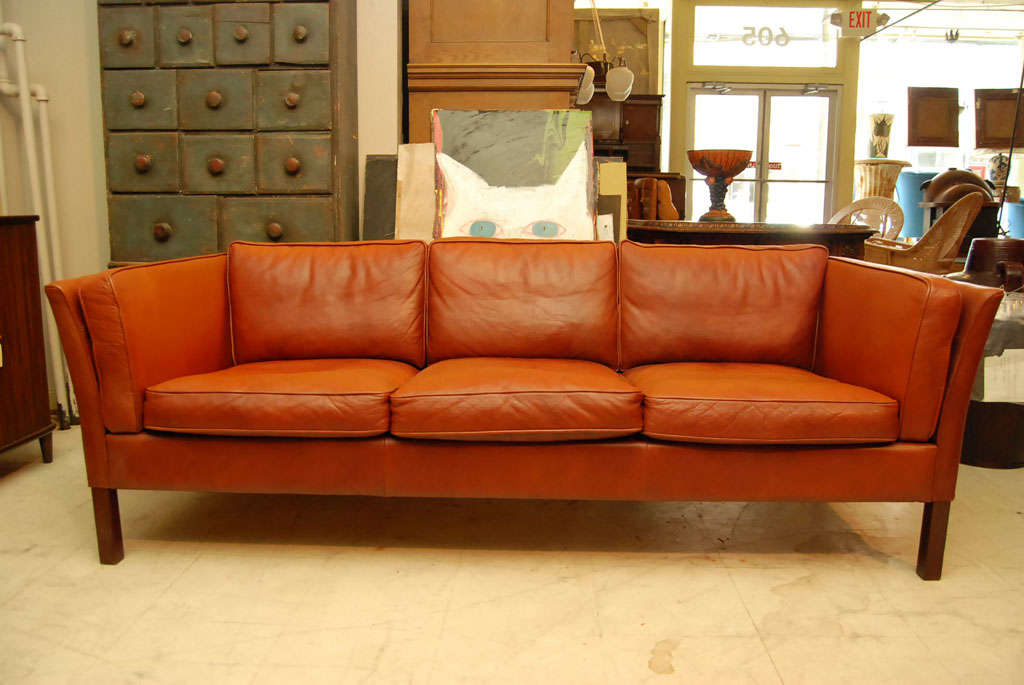 Brown leather sofa, Danish modern, three-seater with cushions, neo-classical form, <br />
with beechwood legs