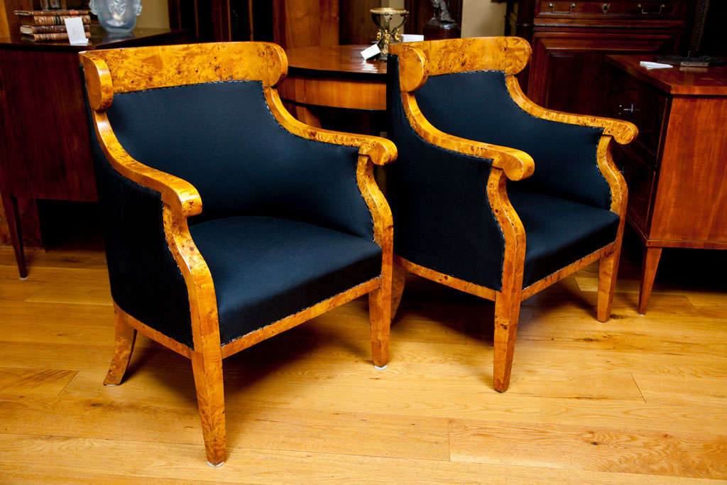 pair of elegant and classic Austrian Biedermeier bergeres in carpathian elm wood. These very classic examples are large and comfortable, shown with shovel shaped backs, downswept and rounded arms, and splayed back legs, recently french