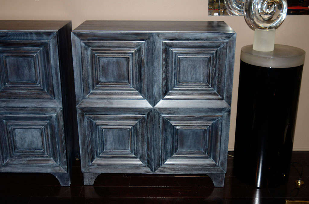 A beautiful pair of grey blue cerused oak bachelor's chests with picture frame doors. Doors fold open to reveal five drawers graduating in size.