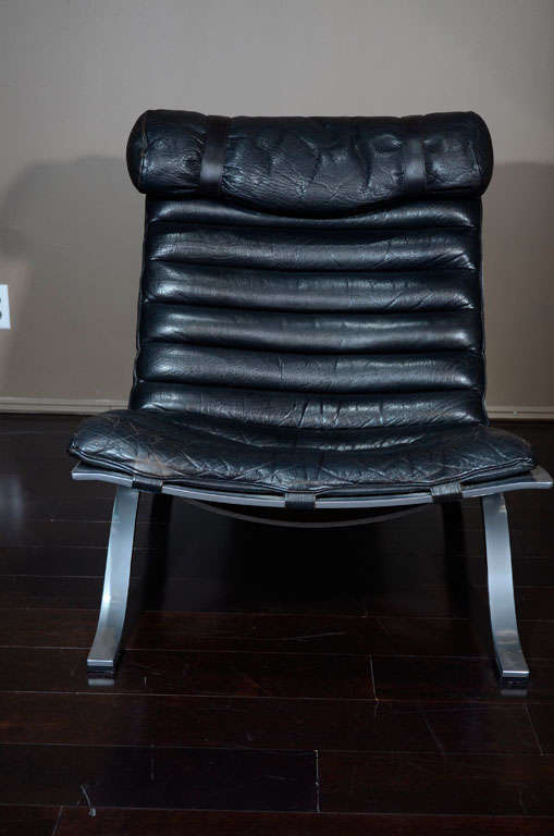 This pair of original Arne Norell lounge chairs have their original channel stitched buffalo leather in wonderful vintage condition. The backs of chairs are strapped with original buckles. Down filled leather headrest is strapped to the steel frame