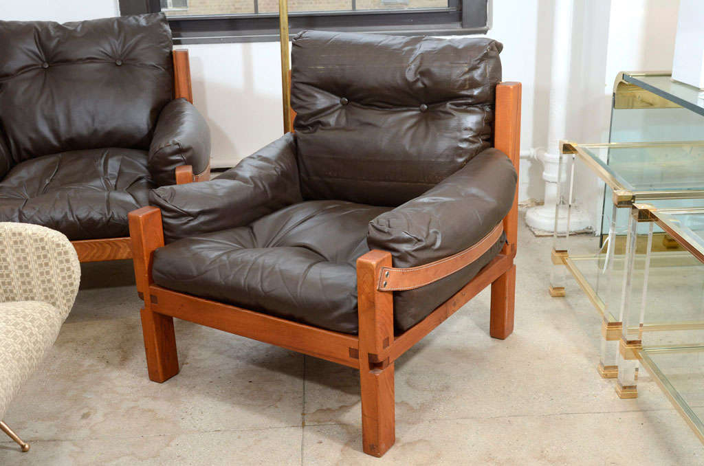 The Pierre Chapo Lounge  chairs created in 1961 offer both luxury and comfort
The pair's over stuffed grey brown cowhide cushions  resting in a chunky solid  wood and boot leather frame are modern yet rustic.