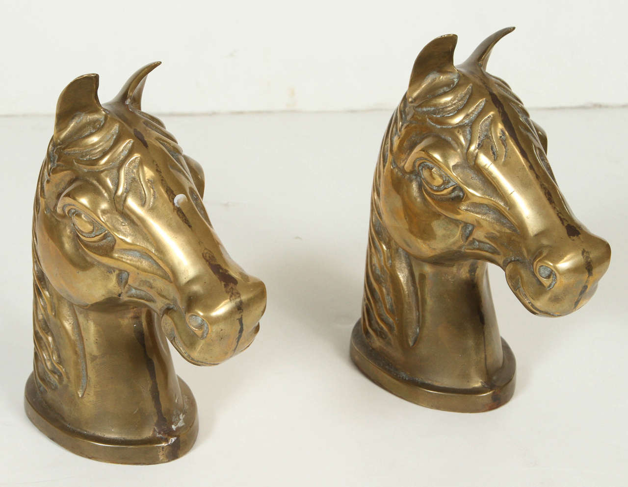 Pair of vintage hollow brass horse heads in the style of Hollywood Regency.