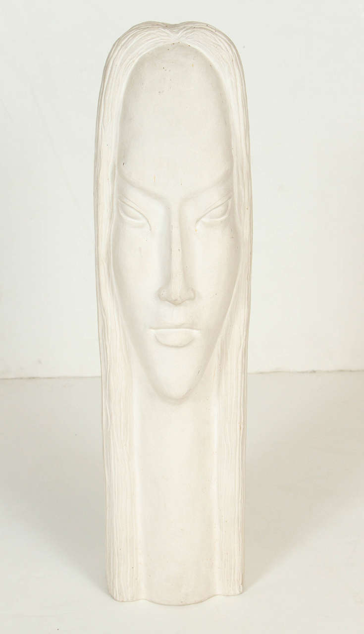 Ceramic white abstract sculpture of a woman’s head.