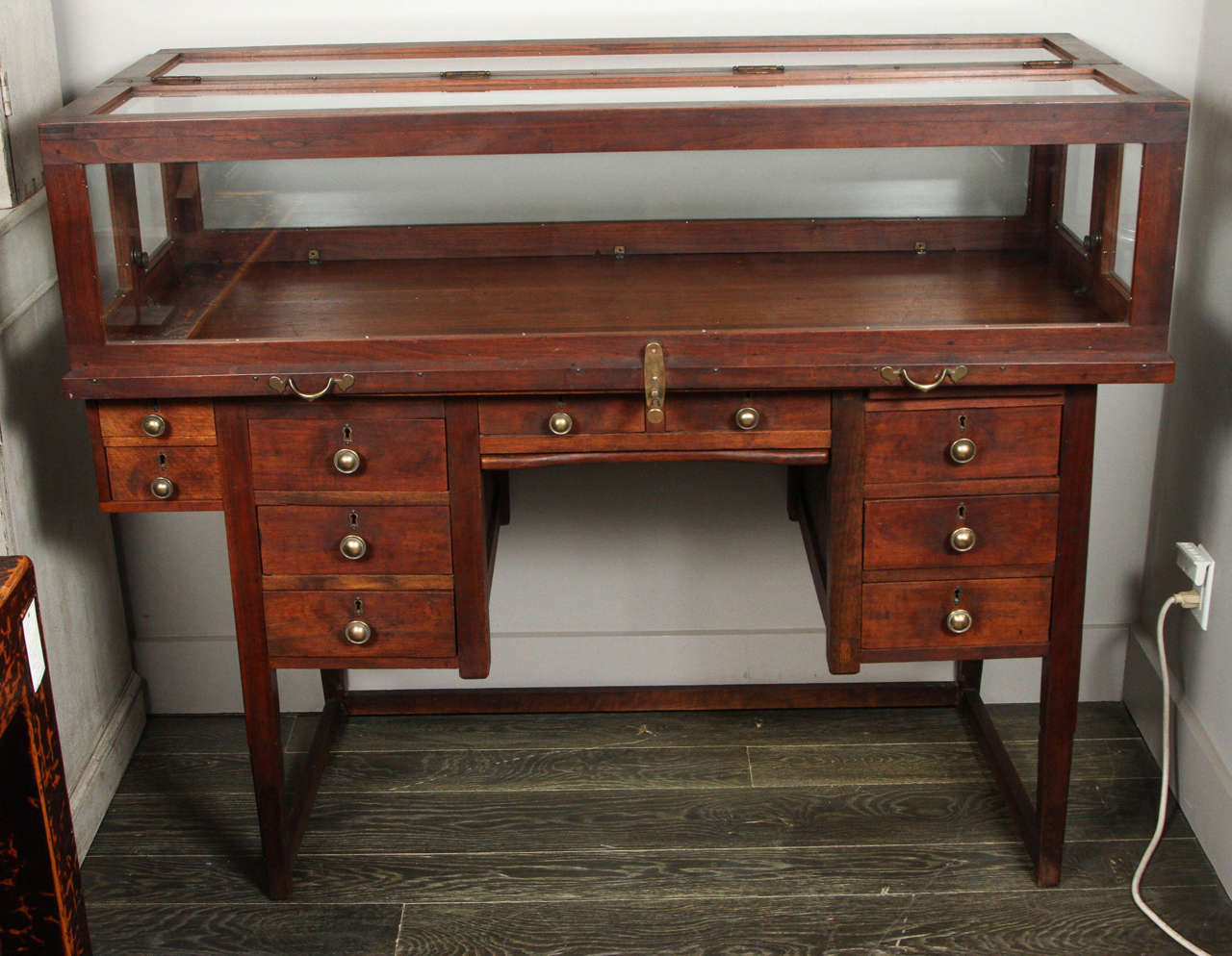 Unique 19th century English jeweler’s work desk and display case on stretcher base, great for displaying and storing collectibles. It has 8 locking drawers and a sliding tray. This desk would be a great piece for use in a study or office, with