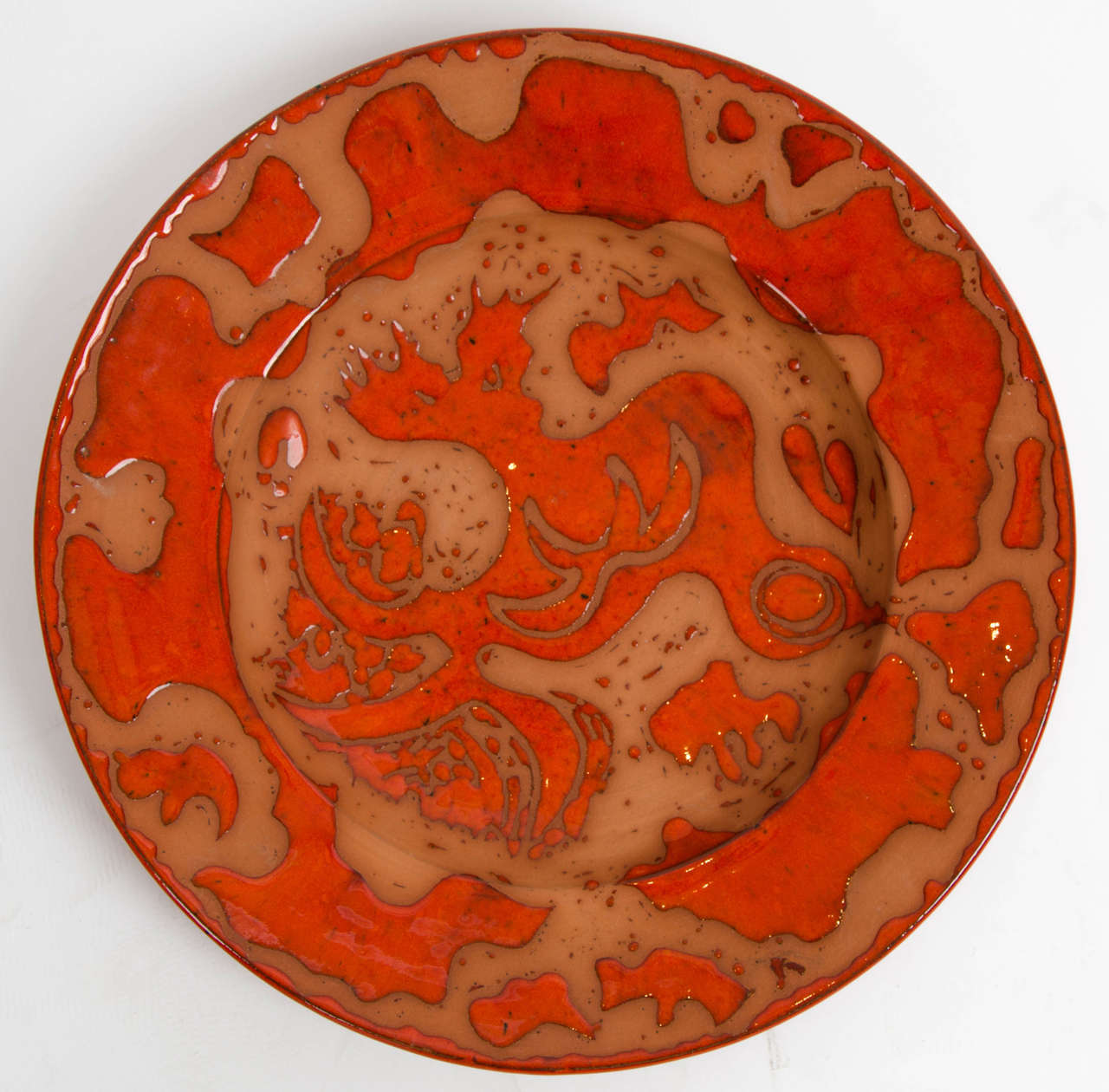 A late 20th century orange glazed modern pottery charger by Geoffrey Eastop  with stylised foul decoration, signed on the reverse.