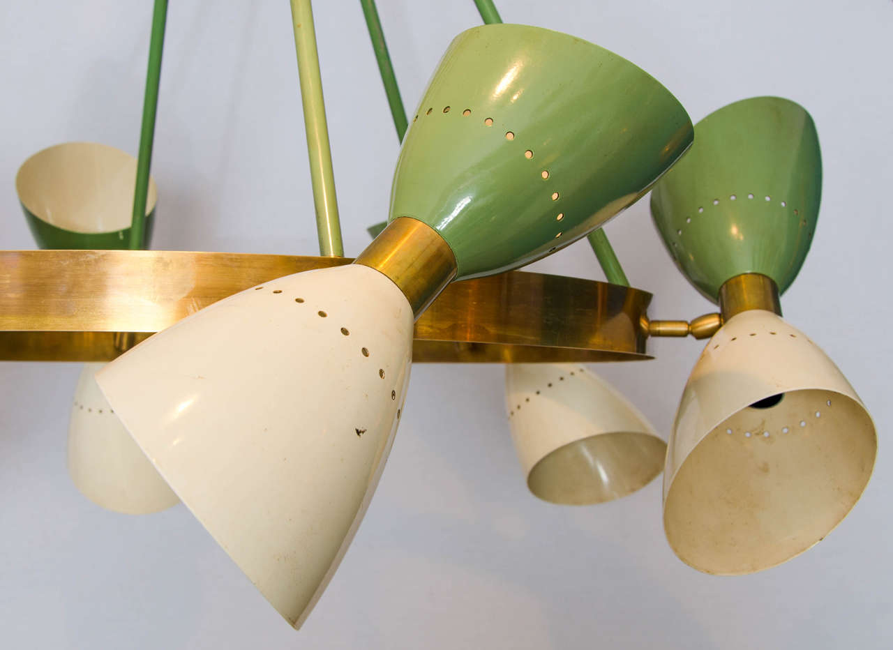 Chandelier with six hourglass shades and twelve adjustable lights in alternate colors green and creme enamel connected by a brass sleeve.