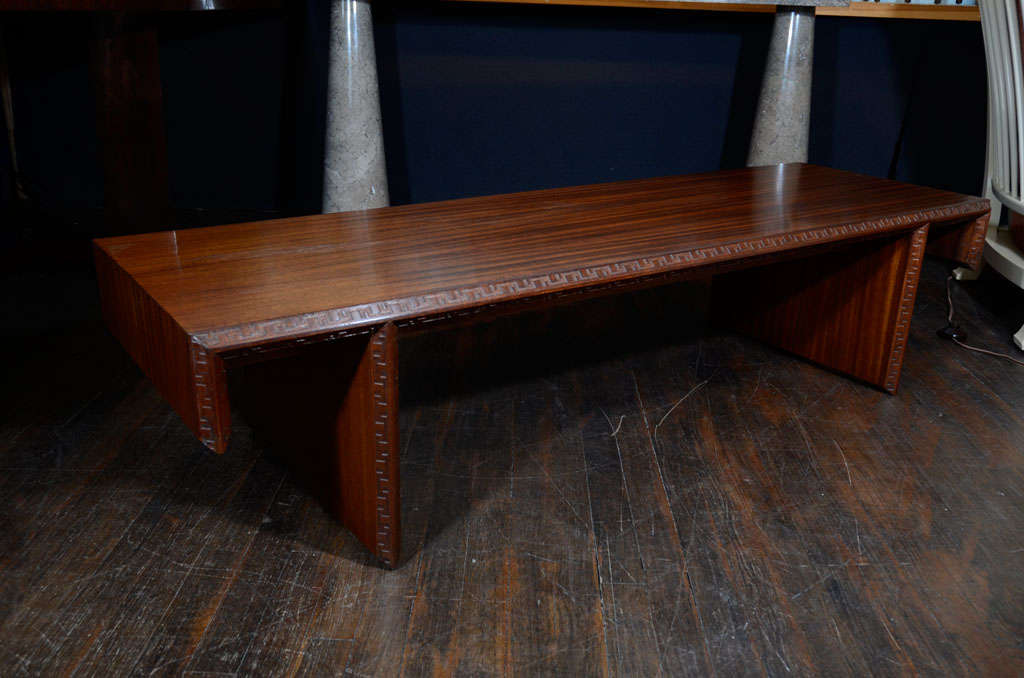Rectangular form in mahogany with modified waterfall sides.  Fin formed base and Taliesin pattern carved on edges.  This table was part of a line that Wright designed for Henredon, and is signed.<br />
*To see our entire inventory, www.donzella.com